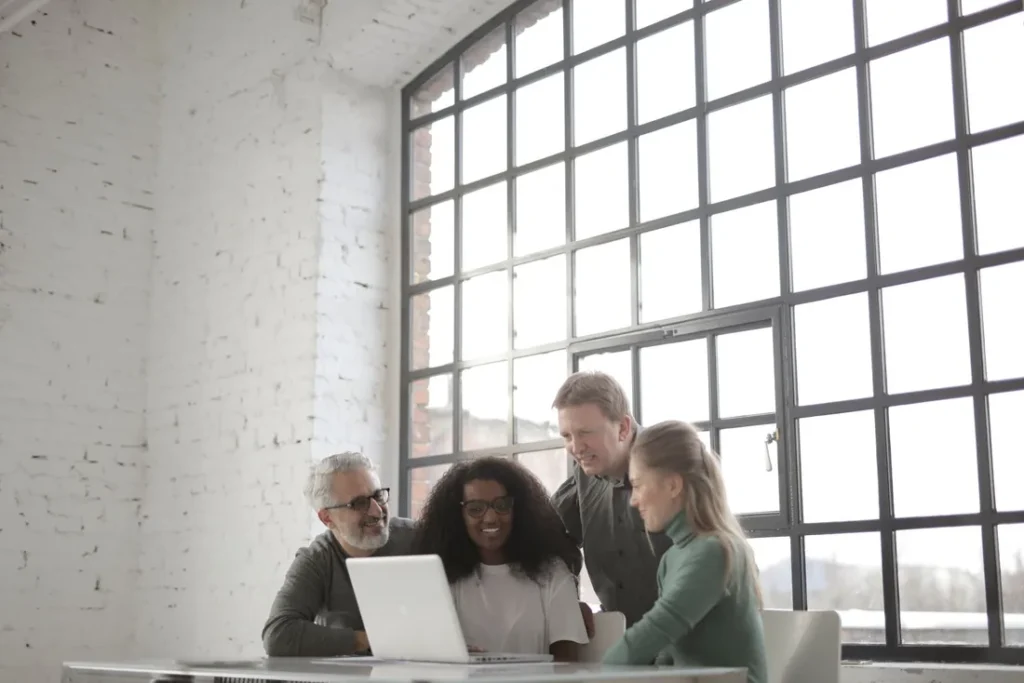 Equipe reunida em torno de um computador.